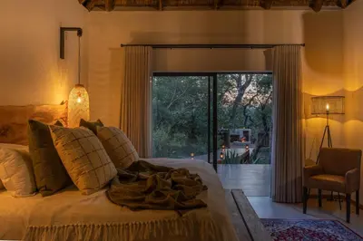 a bedroom with a bed and a sliding glass door at Ukanyi Private Luxury Villa in Hoedspruit