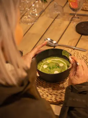 a woman sitting at a table with a bowl of soup at Ukanyi Private Luxury Villa in Hoedspruit