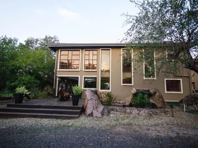 a house with a dog sitting in front of it at The Castello at Kruger in Marloth Park