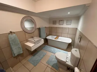 a bathroom with a toilet and a sink and a tub at The Castello at Kruger in Marloth Park