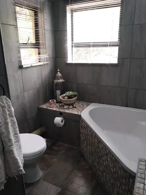 a bathroom with a tub and a toilet and a sink at 4609 Ratel in Marloth Park