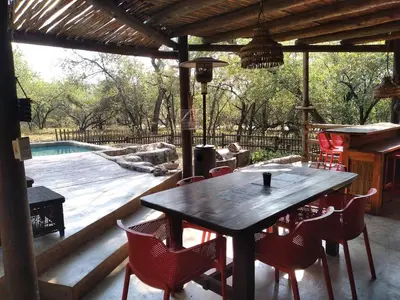 a patio with a table and chairs and a swimming pool at 4609 Ratel in Marloth Park