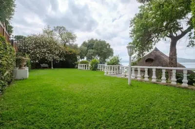 a backyard with a white fence and a grass yard at 147@ Simon Bekker Kosmos in Hartbeespoort