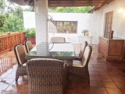 a dining table and chairs on a patio at 147@ Simon Bekker Kosmos in Hartbeespoort