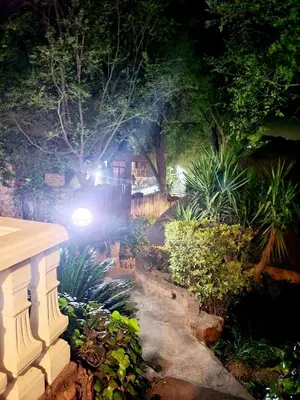 a garden at night with a house in the background at 147@ Simon Bekker Kosmos in Hartbeespoort