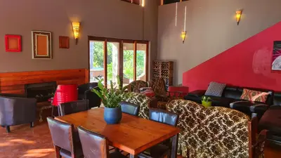 a living room with a wooden table and chairs at The Captain in Pretoria