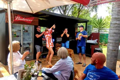 a group of people watching a woman standing in front of a food truck at The Captain in Pretoria