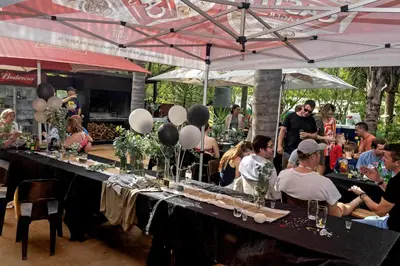 a group of people sitting around a table with balloons at The Captain in Pretoria