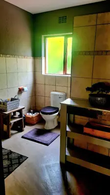 a bathroom with a toilet and a window at The Captain in Pretoria