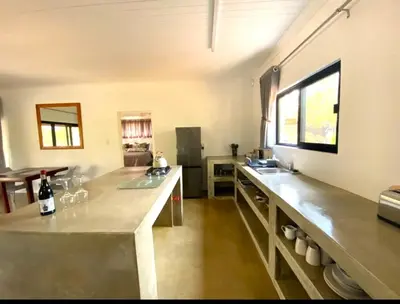 a kitchen with a counter with two sinks and a window at Bushbuck Rest in Marloth Park