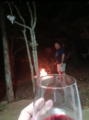 a person holding a wine glass with a candle at Bushbuck Rest in Marloth Park
