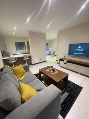 a living room with a couch and a tv at Priceless Cove. Garden Cottage in Midrand