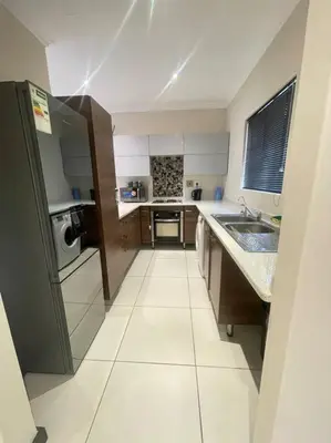 a small kitchen with a sink and a refrigerator at Priceless Cove. Garden Cottage in Midrand