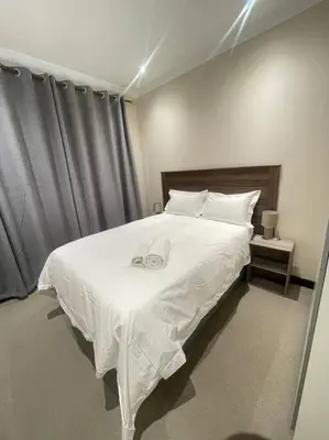 a bedroom with a large white bed with white sheets at Priceless Cove. Garden Cottage in Midrand
