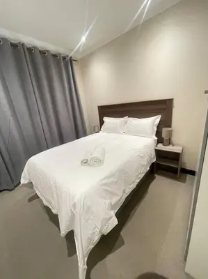 a bedroom with a large white bed with white sheets at Priceless Cove. Garden Cottage in Midrand