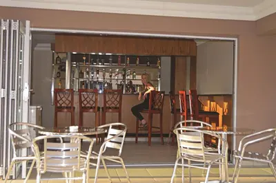 a woman sitting at a bar in a restaurant at Lakeview Boutique Hotel & Conference Center in Benoni