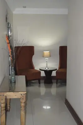 a living room with two chairs and a table at Lakeview Boutique Hotel & Conference Center in Benoni