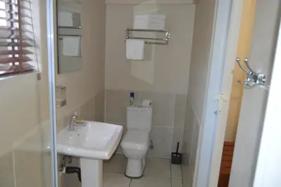 a bathroom with a white toilet and a sink at Lakeview Boutique Hotel & Conference Center in Benoni