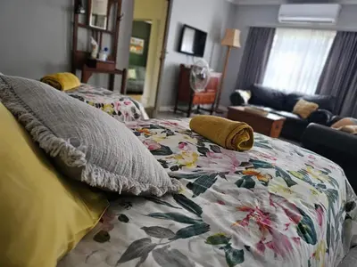 a bedroom with two beds and a living room at Giraffe's Rest, Self Catering Studio Apartment in White River