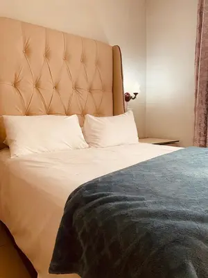 a bedroom with a large bed with white pillows at Sidze Guest House in Polokwane