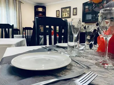 a table with a white plate and glasses on it at Sidze Guest House in Polokwane