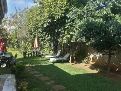 a yard with chairs and tables and a tree at Sidze Guest House in Polokwane