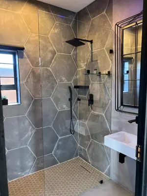 a bathroom with a shower with a glass door at Swan Lake Suites in Benoni
