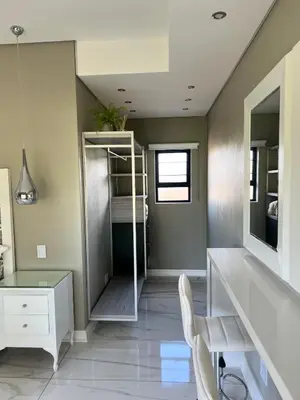 a room with a desk and a bed and a desk and chair at Swan Lake Suites in Benoni