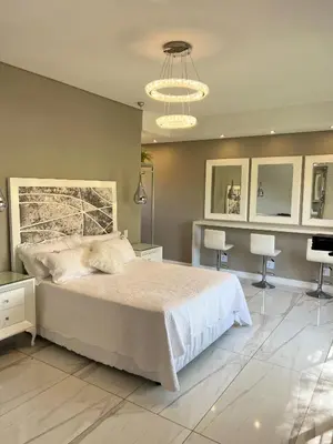 a bedroom with a bed and a table and chairs at Swan Lake Suites in Benoni