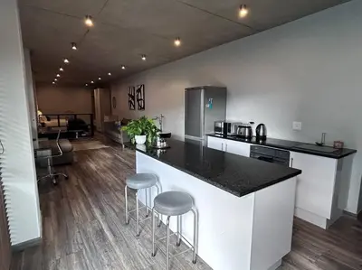a kitchen with a counter and stools in a room at Waterkloof Nature Reserve Studio Apartment in Pretoria