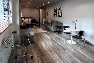 a living room with a table and chairs and a couch at Waterkloof Nature Reserve Studio Apartment in Pretoria