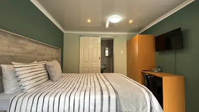 a bedroom with a bed and a flat screen tv at Blue Lantern Bed and Breakfast in Kempton Park