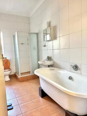a bathroom with a tub and a toilet and a sink at Blue Lantern Bed and Breakfast in Kempton Park