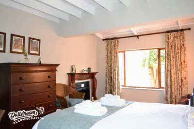 a bedroom with a bed with a dresser and a window at Critchley Common 24 in Dullstroom