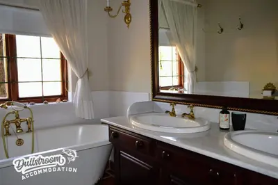a bathroom with two sinks and a tub and a mirror at Critchley Common 24 in Dullstroom