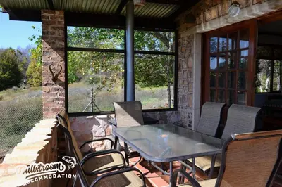 a patio with a table and chairs on a porch at Critchley Common 24 in Dullstroom