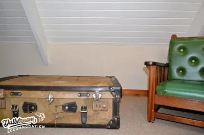 a green chair and an old suitcase next to a chair at Critchley Common 24 in Dullstroom