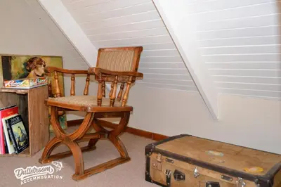 a rocking chair and a suitcase in a room at Critchley Common 24 in Dullstroom