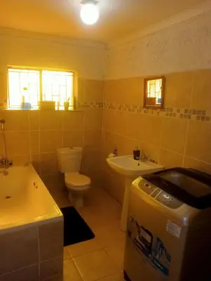 a bathroom with a sink and a toilet and a tub at eManzini Guesthouse in Matibidi