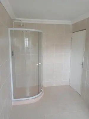a shower with a glass door in a bathroom at eManzini Guesthouse in Matibidi