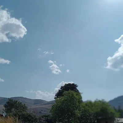 a blue sky with clouds and trees in the foreground at eManzini Guesthouse in Matibidi