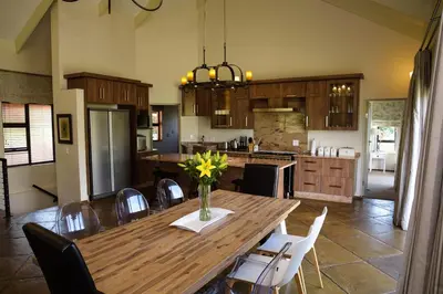 a kitchen with a wooden table with a vase of flowers on it at Walkersons Riverview in Dullstroom