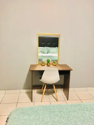 a desk with a mirror and a white chair at Menlyn Comfort in Pretoria