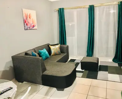 a living room with a couch and a chair at Menlyn Comfort in Pretoria