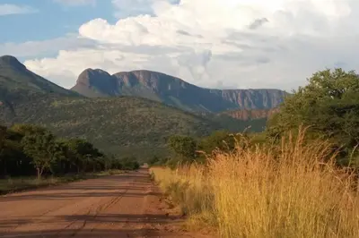 a dirt road with mountains in the background at Waterberg Hideaway in Thabazimbi