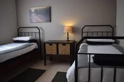 a room with two beds and a table with a lamp at Waterberg Hideaway in Thabazimbi