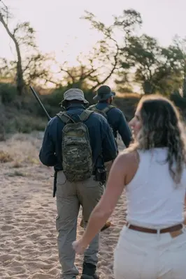a group of three people walking on a beach at Kruger Untamed - Tshokwane River Camp in Skukuza