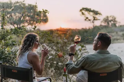 a man and a woman holding wine glasses at Kruger Untamed - Tshokwane River Camp in Skukuza