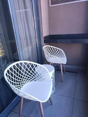 two white chairs and a table on a balcony at Menlyn Maine Trilogy Apartment 509 in Pretoria