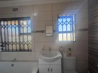 a bathroom with a sink and a toilet and a window at The Dream Guesthouse in Ermelo